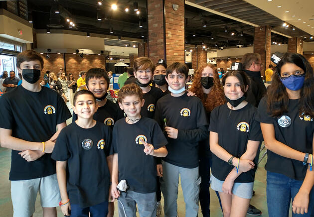 A cartoon alpaca wearing sunglasses with a rainbow above its head.