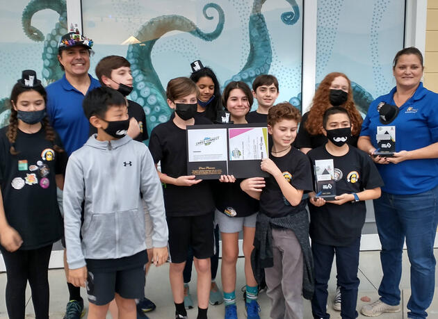 A cartoon alpaca wearing sunglasses with a rainbow above its head.